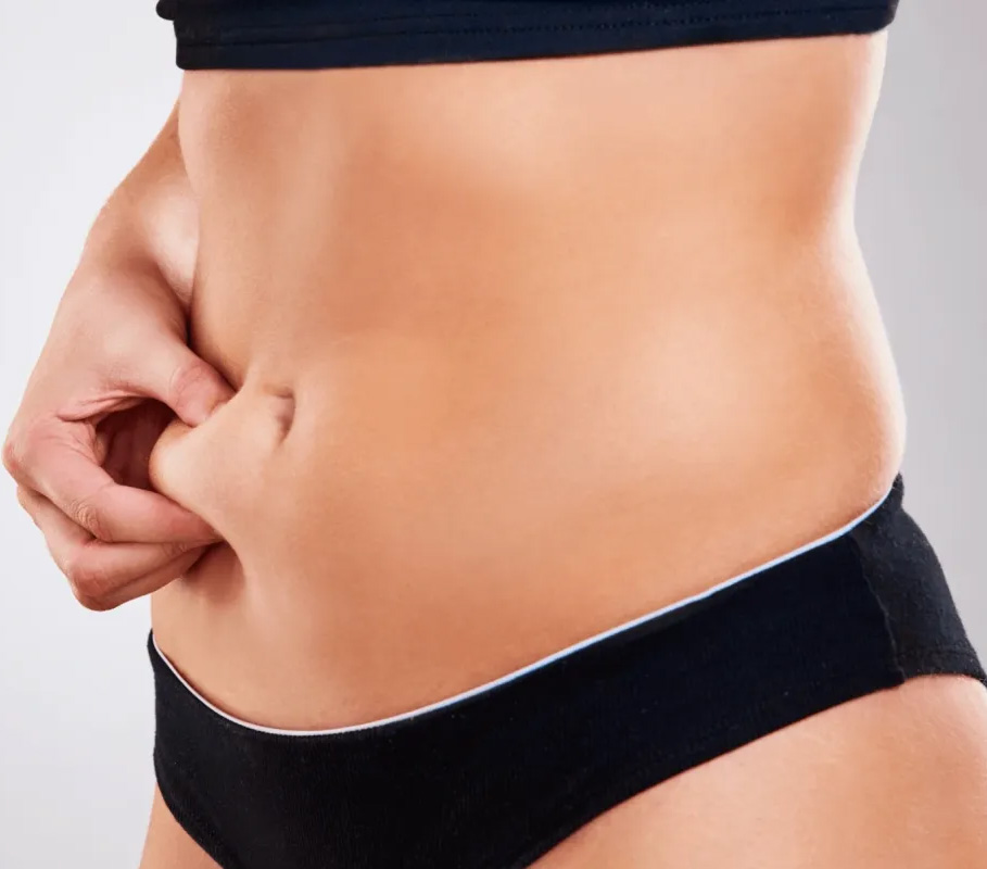 A woman in black underwear is holding her stomach.